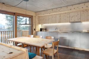 eine Küche und ein Esszimmer mit einem Tisch und Stühlen in der Unterkunft Alpine Lodge Chesa al Parc in Pontresina