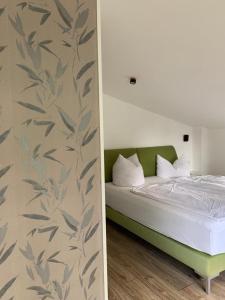 a bedroom with a bed with a leaf pattern on the wall at Landhaus Ankerplatz im Grünen, strandnah , fernab vom mainstream , ideal für Familien in Gorow