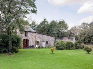an old stone house with a grass yard at The Coach House - Uk35953 in South Pool