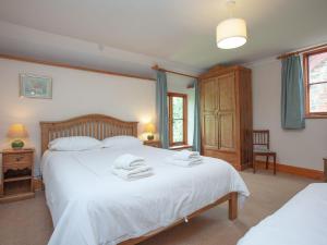 a bedroom with a white bed with towels on it at The Coach House - Uk35953 in South Pool