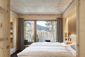 Postel nebo postele na pokoji v ubytování Alpine Lodge Chesa al Parc