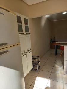 an empty kitchen with a refrigerator and a table at Residencial JOED 3 in Dourados