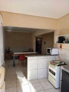 a kitchen with a table and a microwave in it at Residencial JOED 3 in Dourados