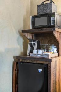 a microwave sitting on a shelf next to a refrigerator at The Rustic Suite - Main Street Lodge in Berlin in Berlin