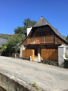Casa de madera con porche y valla en Maisonette 'La Toue' in Pyrenees National Park, en Arrens-Marsous