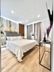 a bedroom with a large white bed and a table at Silver & Brownie, Nuevo apart cerca de la Playa in Playa de las Americas