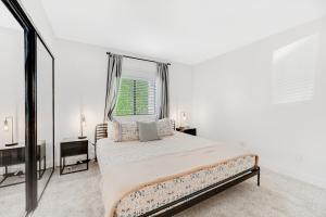 a white bedroom with a bed and a window at Scottsdale Springs in Scottsdale