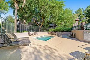 a swimming pool with two chairs and a fence at Scottsdale Springs in Scottsdale