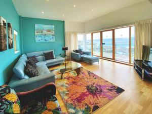 a living room with a couch and a television at 4-bedroom Penthouse - Fistral Beach in Newquay