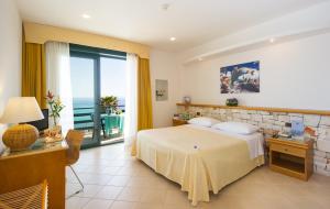 een slaapkamer met een bed en uitzicht op de oceaan bij Hotel Terminal - Caroli Hotels in Leuca
