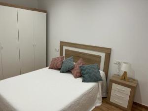 Un dormitorio con una cama blanca con almohadas. en Agradable casa familiar en Pliego. en Pliego