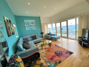 a living room with a couch and a table at 4-bedroom Penthouse - Fistral Beach in Newquay