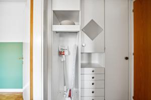 a white bathroom with a sink and a dresser at Central Lucerne Apartments in Lucerne