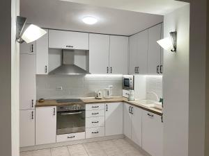 a white kitchen with white cabinets and a sink at Fenix 2 Bedroom Apartment Varna Center in Varna City