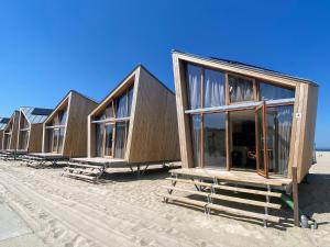 a row of tiny houses on a beach at Breezand Beachhouses in Vrouwenpolder