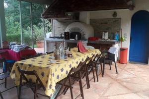 jadalnia ze stołem, krzesłami i piekarnikiem w obiekcie Villa de 4 chambres avec piscine privee terrasse amenagee et wifi a Jurancon w mieście Jurançon
