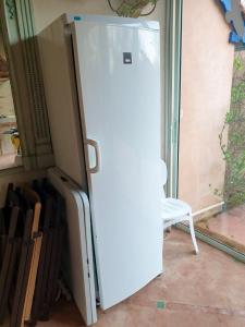 a white refrigerator in a room with a chair at Villa de 4 chambres avec piscine privee terrasse amenagee et wifi a Jurancon in Jurançon