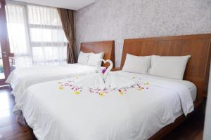 塞亚特Lembah Ciater Resort Managed by Sahid的一间酒店房间里有两张铺着鲜花的床