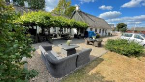 a backyard with a couch and tables and a house at Nørbygaard Fanø in Fanø