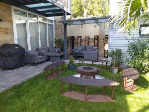 d'une terrasse avec des canapés et des tables sur la pelouse. dans l'établissement Villa Johner, à Bayreuth