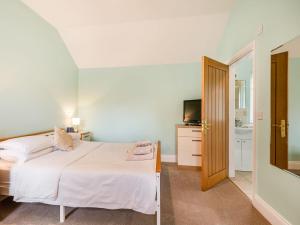 a bedroom with a white bed and a television at The Stables - Uk36121 in Horsington