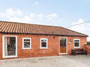 a brick house with a bench in front of it at The Stables - Uk36121 in Horsington