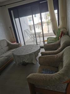 a living room with couches and a table and a patio at mehdiya plage in Kenitra