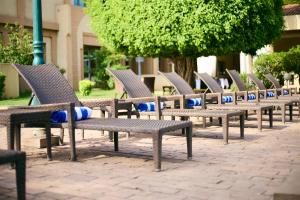 una fila di panchine sedute su un marciapiede di mattoni di Dunia Hotel Bamako a Bamako