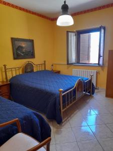 2 camas en una habitación con paredes amarillas en Appartamento con giardino e parcheggio riservato en Narni