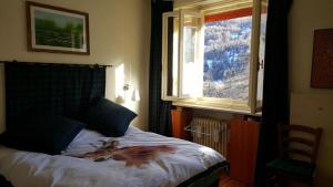 a bedroom with a bed and a window with a horse on it at The Panoramico in Sauze dʼOulx