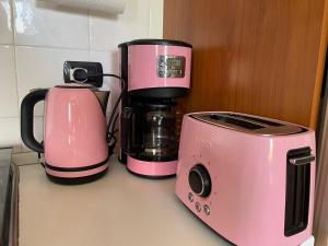 a pink coffee maker and a toaster on a counter at The Panoramico in Sauze dʼOulx