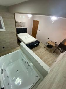 a bathroom with a bath tub and a bed at Pousada Leitzke in Piratini +151 photos