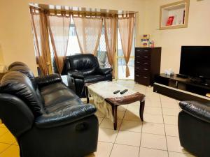a living room with leather chairs and a coffee table at ParkViewAtMontagueFarm in Mawson Lakes