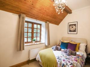 a bedroom with a bed and a wooden ceiling at Barley Cottage in Axminster