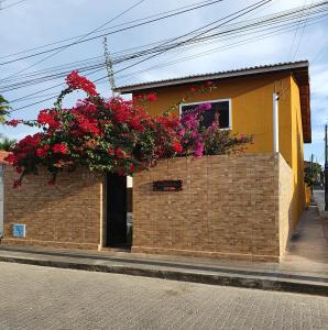 ムンダウーにあるCasa do Bougainvillea Mundaú-Trairi-Ceのレンガ造りの建物で、花が咲く窓があります。