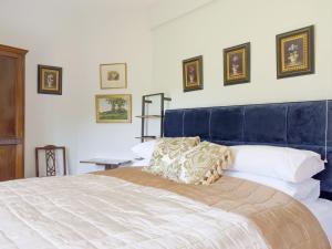 um quarto com uma cama grande e uma cabeceira azul em The Pump House em Kiddemore Green