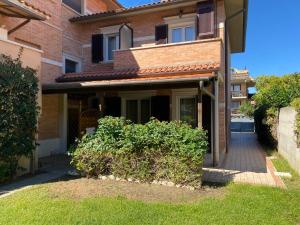 a brick house with a walkway in front of it at Ville sul Mare in Marina di Grosseto