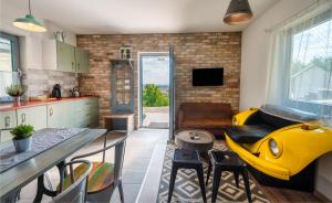 a kitchen and living room with a yellow object in the middle at Borárium Vendégházak - Zenit Ház in Pázmánd