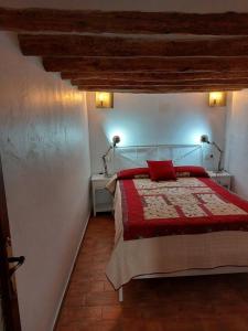 1 dormitorio con 1 cama con manta roja y 2 lámparas en Casa de Pueblo Encantadora en San Jordi, Castellon, en Sant Jordi