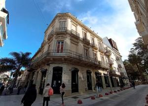 Un edificio in una strada con gente che cammina davanti di Zabalita, hermoso y cálido loft en la Ciudad Vieja a Montevideo