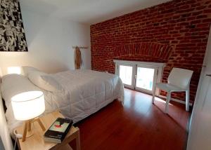 a bedroom with a bed and a brick wall at Zabalita, hermoso y cálido loft en la Ciudad Vieja in Montevideo