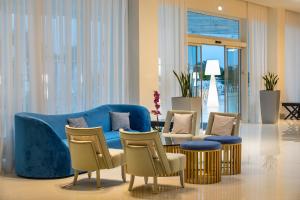 a living room with a blue couch and chairs at Constantinos the Great Beach Hotel in Protaras