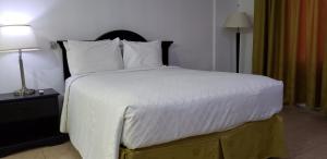 a bedroom with a large bed with white sheets and pillows at Gran Hotel CCP Suites in Maturín