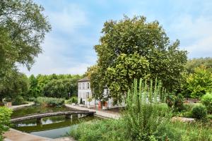 une maison au milieu d'un jardin avec un étang dans l'établissement Hotel Campanile Paris-Bercy Village, à Paris