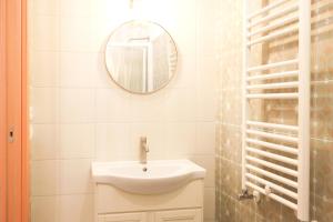 a white bathroom with a sink and a mirror at Casa Il giuggiolo in Giuncarico