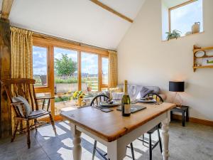 a dining room with a table and chairs and windows at The Hovel in Fenny Compton