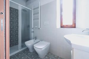 a bathroom with a toilet and a sink and a shower at Casa Il giuggiolo in Giuncarico