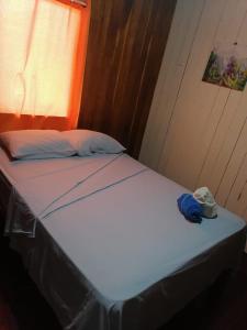 Una cama en una habitación con una toalla azul. en El Jaguar, en Bocas Town