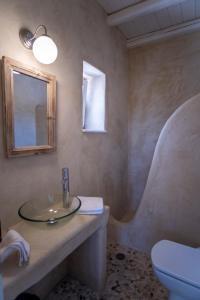 a bathroom with a sink and a toilet and a mirror at Scenic Seaview villa Iris at Faragas in Angairiá
