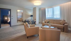 un soggiorno con divano e sedie di voco - Podgorica by IHG a Podgorica